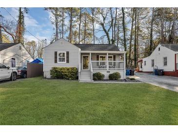 Charming home featuring a well-maintained front yard, a covered porch, and beautiful landscaping at 2912 Palm Dr, East Point, GA 30344