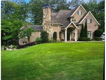 Charming two-story brick home with a manicured lawn and stone chimney at 5172 Roswell Rd, Marietta, GA 30062