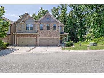 Charming townhome with a two-car garage, brick accents, and a well-manicured front lawn at 2333 White Oak Se Bnd, Smyrna, GA 30080