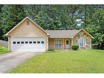 Charming single-story home with a two-car garage, stone accents, and a well-maintained lawn at 7847 Dogwood Way, Douglasville, GA 30134