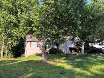 Charming home nestled among mature trees, featuring a well-maintained lawn and inviting curb appeal at 3230 Plymouth Rock Dr, Douglasville, GA 30135