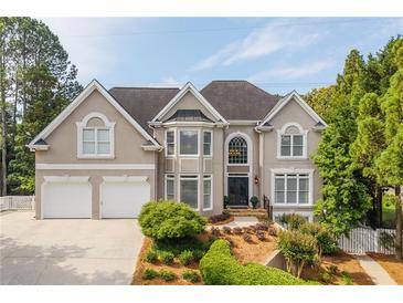 Charming two-story home features a manicured front lawn, two-car garage, and classic architectural details at 3495 Mill Bridge Dr, Marietta, GA 30062