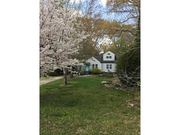 Charming home with manicured lawn, flowering trees, and a lovely teal front door at 136 Bucher Dr, Decatur, GA 30030