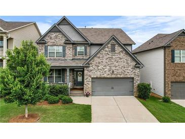 Charming two-story home with a well-manicured lawn and a two-car garage at 216 Orchard Trl, Canton, GA 30115
