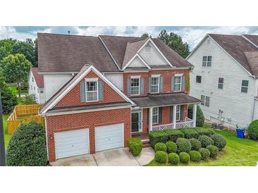 Charming two-story brick home with a covered porch, landscaped yard, and two-car garage at 5280 Lakerock Way, South Fulton, GA 30331