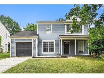 Charming two-story home featuring a well-maintained lawn, attached garage, and inviting front porch at 6279 Marbut Farms Rd, Lithonia, GA 30058
