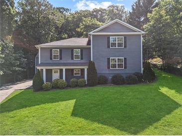 Charming two-story home featuring a lush green lawn and well-maintained landscaping at 2067 Kinridge Ct, Marietta, GA 30062