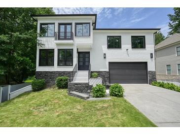 Stunning two-story white brick home with a black garage, modern black window frames, and beautiful landscaping at 2804 Skyland Ne Dr, Brookhaven, GA 30341