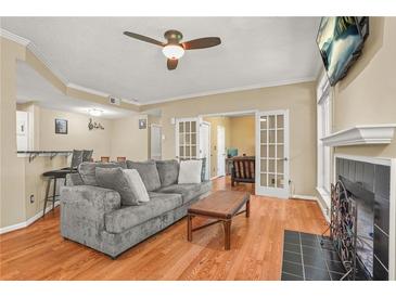 Cozy living room features a fireplace, ceiling fan, and open floor plan at 539 Mcgill Park Ne Ave, Atlanta, GA 30312