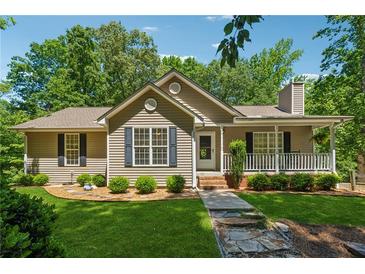 Charming single-story home with a well-manicured lawn, stone walkway, and inviting front porch at 6960 Worley Rd, Cumming, GA 30028