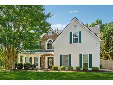 Charming two-story home featuring stone accents, a covered porch, and lush green landscaping at 1093 Forest View Sw Ln, Lilburn, GA 30047