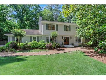 Charming two-story home featuring a well-manicured lawn, mature trees, and classic architectural details at 435 Grenock Cir, Atlanta, GA 30328