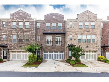 View of brick townhome with attached garages, manicured landscaping and inviting curb appeal at 3133 Quinn Pl, Atlanta, GA 30341