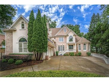 Elegant two-story home with manicured landscaping, brick accents and a circular driveway at 8630 Moor Park Run, Duluth, GA 30097
