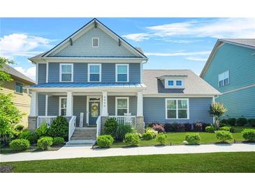Charming two-story home with a welcoming front porch, well-manicured lawn, and beautiful landscaping at 9990 Blackfriars Rd, Douglasville, GA 30135