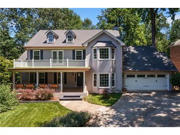 Charming two-story home with a welcoming porch and manicured lawn, nestled among mature trees at 1180 Branch Water Ct, Dunwoody, GA 30338