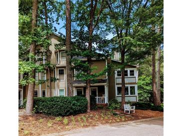 Inviting exterior of a multi-story condo surrounded by lush greenery and mature trees at 1416 Oakridge Cir, Decatur, GA 30033
