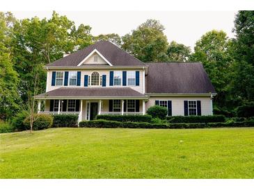 Inviting two-story home featuring a charming front porch and mature landscaping at 8601 Flint Hill Rd, Douglasville, GA 30135