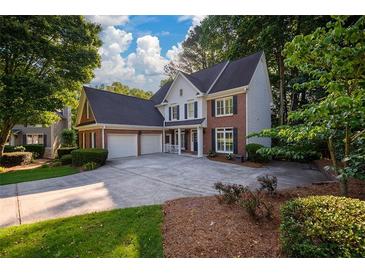 Charming two-story brick home with a large driveway and well-manicured landscaping at 1304 Carrington Way, Lawrenceville, GA 30044