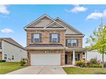 Charming two-story brick home with a well-manicured lawn and attached two-car garage at 6094 Whitetail Deer Run, Mableton, GA 30126