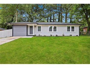 Charming single-story home with a well-manicured lawn and freshly painted white brick at 1770 Atherton Dr, Decatur, GA 30035