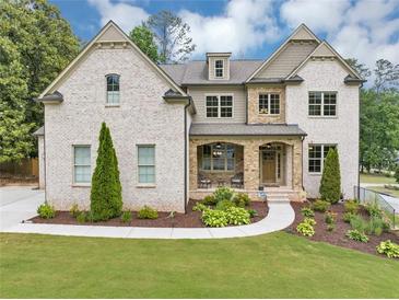Beautiful two-story brick home with a manicured lawn and stone porch at 3459 Clubland Dr, Marietta, GA 30068