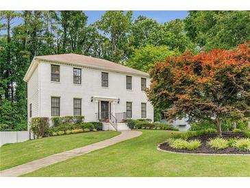 Charming two-story home with a brick facade, mature trees, and a well-manicured lawn at 1560 Boxwood Nw Trce, Acworth, GA 30102