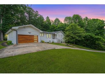 Charming home with a modern garage door and lush landscaping at 4025 Cheoah Dr, Douglasville, GA 30135