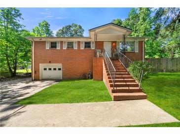 Charming brick home featuring a well-maintained front yard and inviting entrance stairs at 14301 Veterans Memorial Highway, Villa Rica, GA 30180
