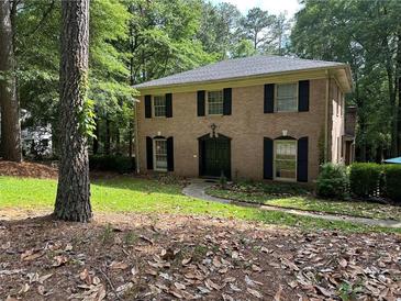 Charming two-story brick home with black shutters and a well-manicured lawn at 2315 Hudson Sw Dr, Lilburn, GA 30047