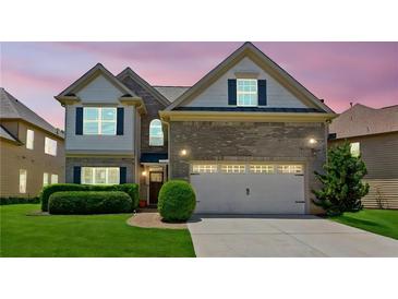 Two-story home with manicured lawn, brick accents, two-car garage, and a pathway to the front door at 2185 Creole Cir, Cumming, GA 30040