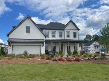 Beautiful new construction featuring a painted brick facade, covered entry and well manicured lawn and flower beds at 750 Keystone Dr, Woodstock, GA 30188