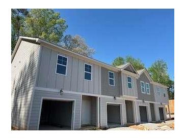 New construction townhome exterior featuring attached garages and neutral color palette at 4255 Sw Notting Hill Sw Dr, Atlanta, GA 30331