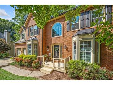 Charming brick home featuring a welcoming porch and manicured landscaping at 1313 Cobblestone Ln, Woodstock, GA 30189