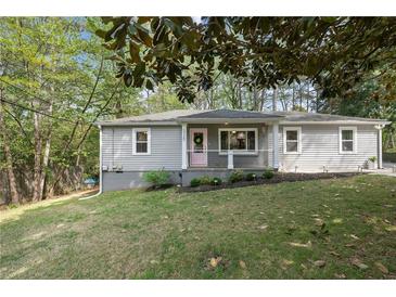 Charming single-story home featuring gray siding, a pink front door, and well-maintained landscaping at 5725 Brenda Sw Dr, Mableton, GA 30126