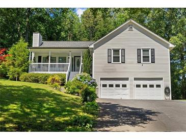 Charming home features a two-car garage, covered front porch, and lush landscaping at 12 Ranger Se Rd, Cartersville, GA 30121