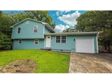Charming two-story home featuring an attached garage and well-maintained lawn at 1328 Hoy Taylor Dr, Norcross, GA 30093