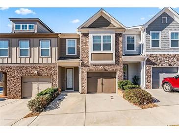 Charming townhome features a brick facade, inviting front door, attached garage and well-maintained landscaping at 2309 Rolling Trl, Lithonia, GA 30058