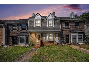 Charming townhome with brick facade, dormer windows, and inviting front lawn at 3244 Hampton Se Ct, Smyrna, GA 30082