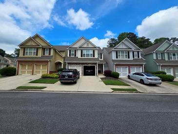 Inviting townhome exterior with a brick-accented garage and well-manicured lawns under a beautiful sky at 1067 Brownstone Dr # 23, Marietta, GA 30008