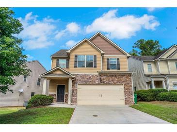 Charming two-story home with stone accents, a two-car garage and manicured lawn at 5123 Jack Dr, Decatur, GA 30035