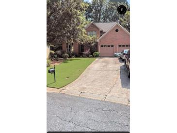Charming brick home with a well-manicured lawn and a two-car garage, perfect for suburban living at 1593 Poplarwood Lane Northwest Ln, Lawrenceville, GA 30043