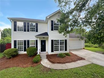 Charming two-story home with black shutters, a manicured lawn, and a two-car garage at 4311 Marci St, Snellville, GA 30039