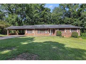 Charming single story brick home featuring a covered carport and lush green lawn at 2386 Springrun Way, Decatur, GA 30032