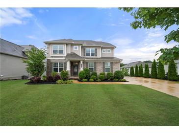 Beautiful two-story home with a well-manicured lawn, garden beds, and a welcoming entrance at 307 Cochin Dr, Woodstock, GA 30188