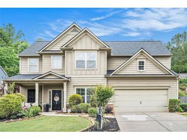 Charming two-story home featuring manicured lawn, neutral siding, a dark roof, and an attached two-car garage at 230 Haleys Ct, Woodstock, GA 30188