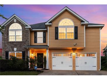 Charming two-story home with a two-car garage and inviting curb appeal against a vibrant sunset at 2584 Grayton Loop, Villa Rica, GA 30180