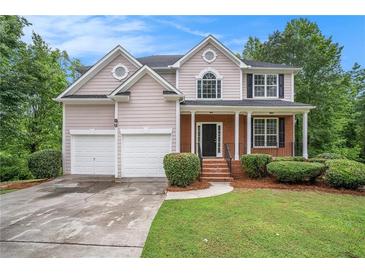 Charming two-story home with a well-manicured lawn and a two-car garage at 2681 Lakeside Sw Dr, Conyers, GA 30094