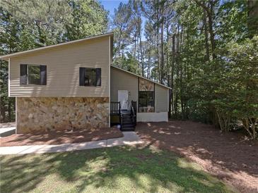 Inviting exterior of a two-story home with stone accents and mature trees at 3924 Chimney Ridge Ct, Ellenwood, GA 30294