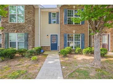 Charming townhome with brick and siding exterior, featuring blue shutters and a well-maintained front yard at 1851 Grove Way, Hampton, GA 30228